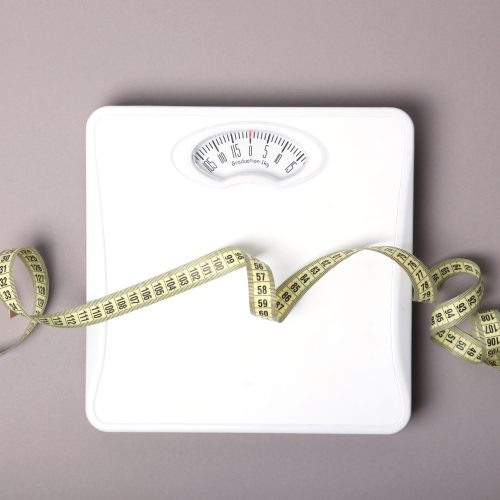 floor scales and tape measure on a colored background top view. Healthy lifestyle concept, healthy eating. Body weight control. High quality photo